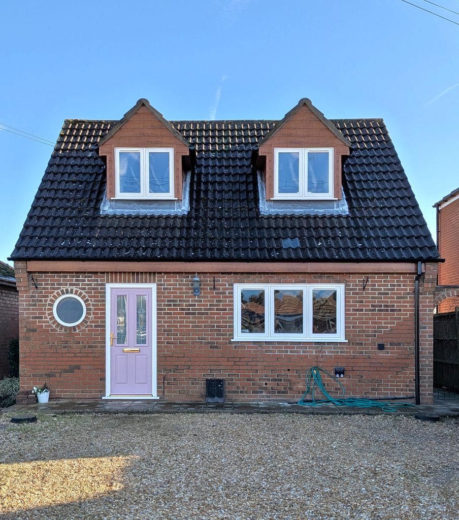 Full House of Flush Casement Windows, Circle Window, Pink Composite Door, Golden Oak Fascia & Dormer Cladding installed on a home in Kirton, Lincolnshire